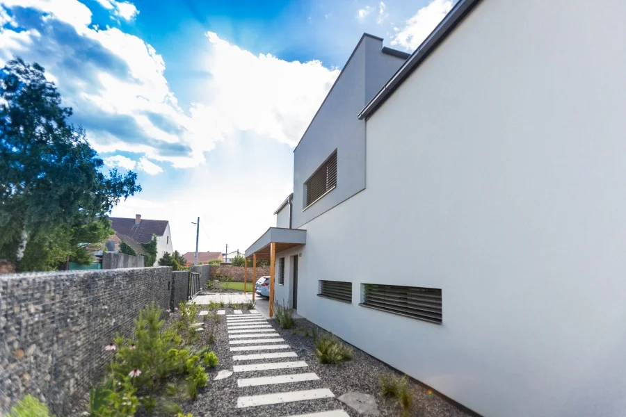 Exteriér – Rodinný dům Dolní Dunajovice, příjezdová cesta z dlažebních pásů podél gabionové zdi
