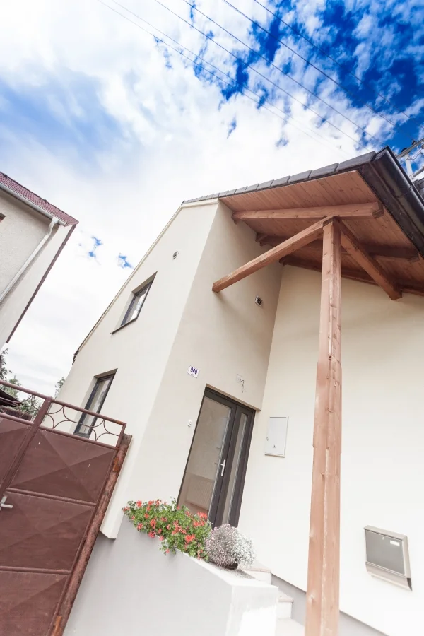 Exteriér – Rodinný dům Mutěnice, detail vstupu s dřevěným přístřeškem na trámových sloupech